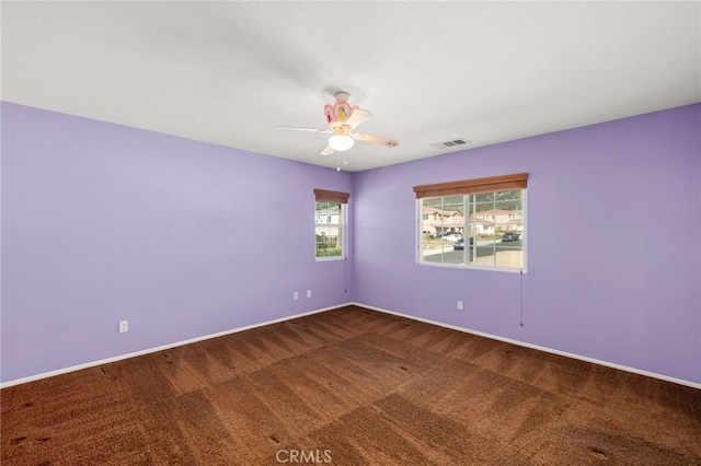 carpeted spare room featuring ceiling fan