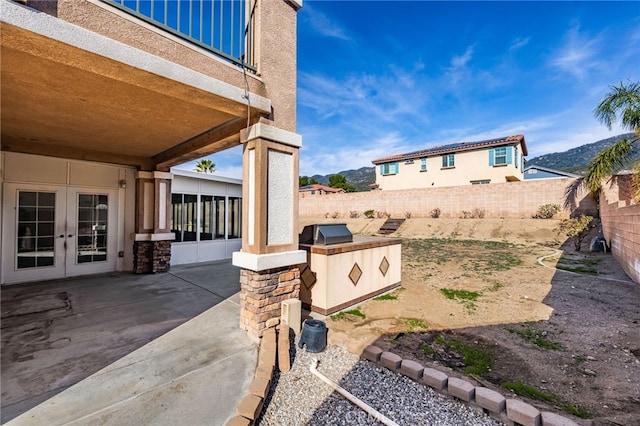 view of yard featuring french doors, area for grilling, a mountain view, and a patio