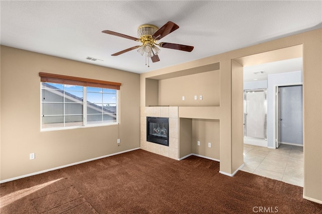 unfurnished living room featuring ceiling fan, light colored carpet, and a fireplace