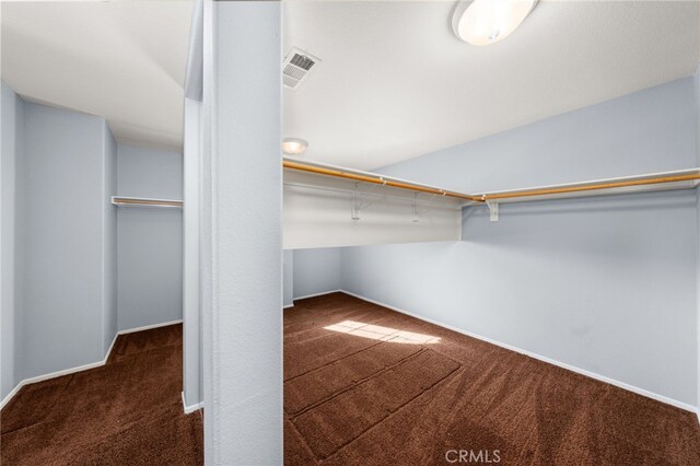 walk in closet featuring dark colored carpet and vaulted ceiling