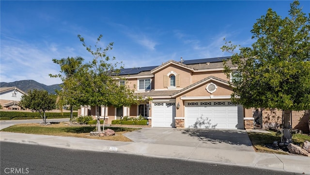 view of front of property with a mountain view, solar panels, and a garage