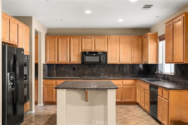 kitchen featuring sink, light tile patterned floors, black appliances, and a kitchen island