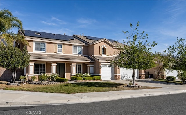 view of front of property featuring solar panels and a garage