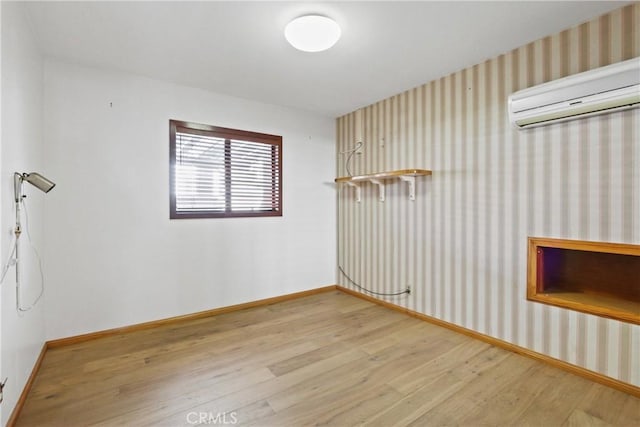 empty room featuring hardwood / wood-style floors and a wall unit AC