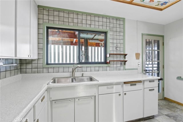 kitchen featuring white cabinetry, backsplash, and sink