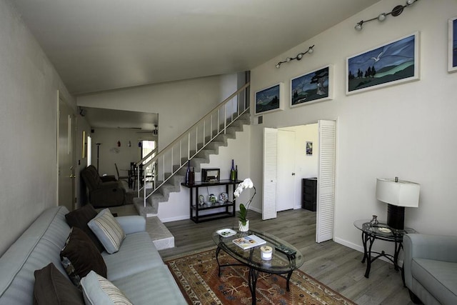 living room featuring ceiling fan, vaulted ceiling, and dark hardwood / wood-style flooring