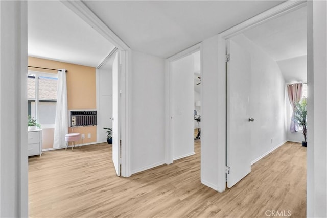 corridor with heating unit and light hardwood / wood-style flooring