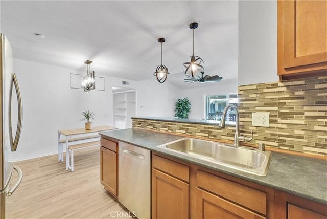 kitchen with pendant lighting, stainless steel appliances, sink, backsplash, and ceiling fan