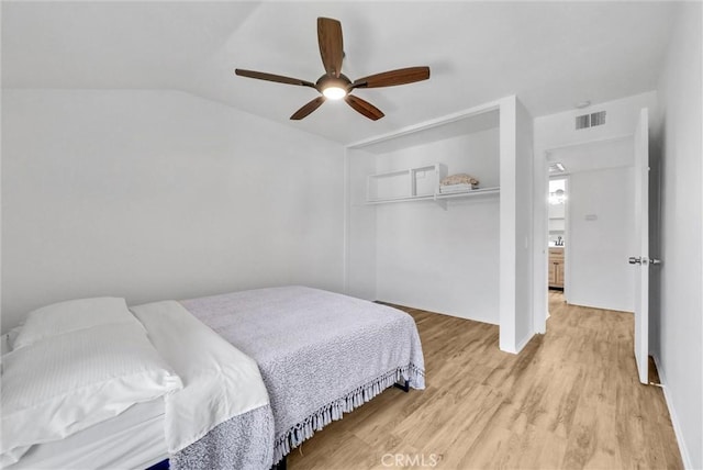 bedroom featuring ceiling fan, a closet, vaulted ceiling, and light wood-type flooring