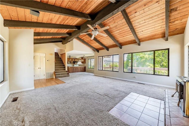 unfurnished living room with beamed ceiling, ceiling fan, light carpet, and wooden ceiling