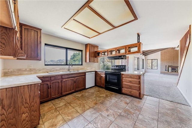 kitchen featuring a fireplace, dishwasher, black electric range oven, sink, and light carpet