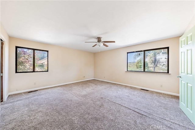 unfurnished room with light colored carpet and ceiling fan