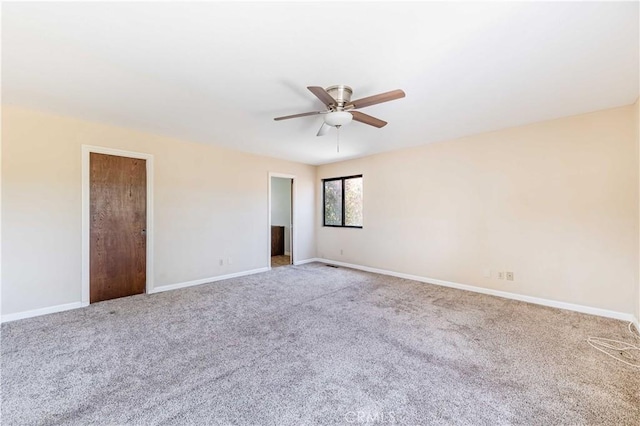 carpeted spare room featuring ceiling fan