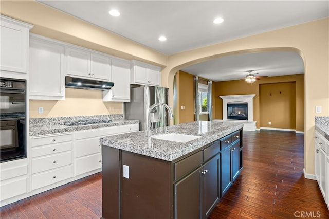 kitchen with a center island with sink, stainless steel appliances, white cabinets, and sink