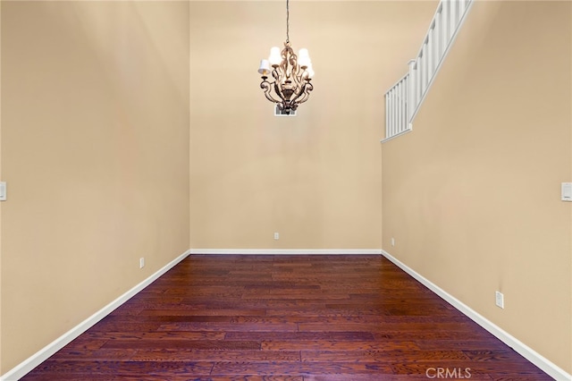 interior space featuring dark hardwood / wood-style flooring and an inviting chandelier