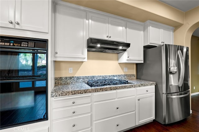 kitchen featuring stone counters, dark hardwood / wood-style floors, appliances with stainless steel finishes, and white cabinetry