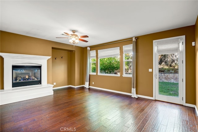 unfurnished living room with ceiling fan and dark hardwood / wood-style flooring