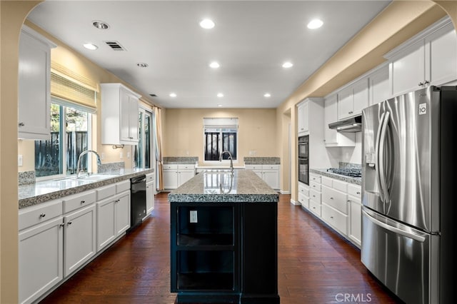 kitchen featuring an island with sink, dark wood-type flooring, black appliances, white cabinets, and sink