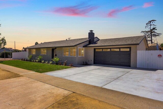 single story home with a garage and a lawn