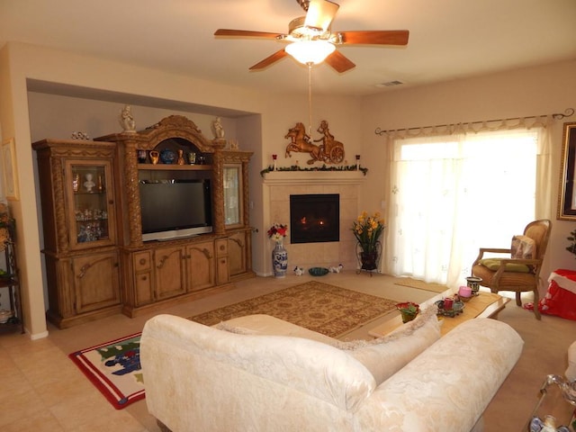 living room featuring ceiling fan and a fireplace