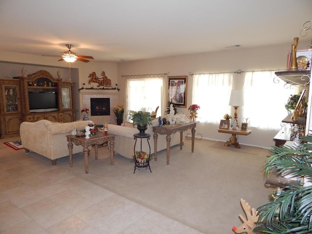 living room with ceiling fan, light colored carpet, and a fireplace