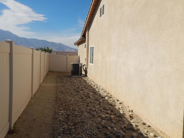 view of side of property with central AC and a mountain view