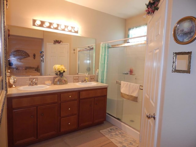 bathroom featuring a shower with shower door, tile patterned floors, and vanity