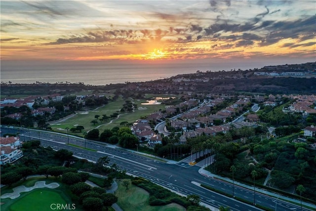 aerial view at dusk featuring a water view