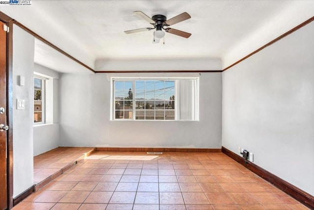 tiled empty room featuring ceiling fan and a healthy amount of sunlight