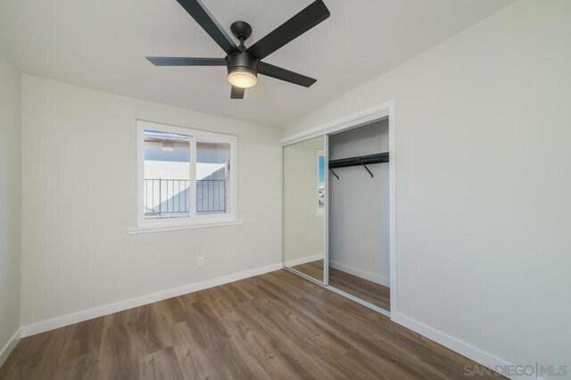 unfurnished bedroom with ceiling fan, a closet, and wood-type flooring