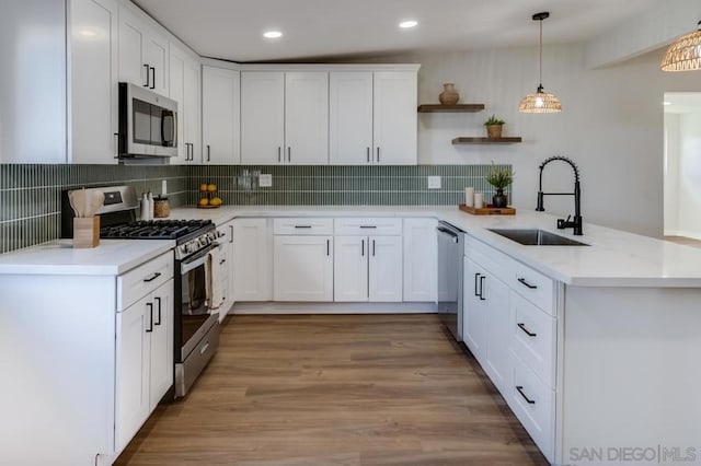 kitchen featuring white cabinets, kitchen peninsula, and stainless steel appliances