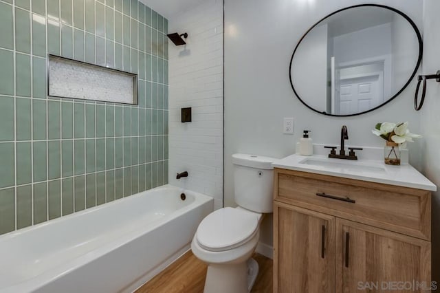 full bathroom featuring toilet, tiled shower / bath combo, hardwood / wood-style flooring, and vanity