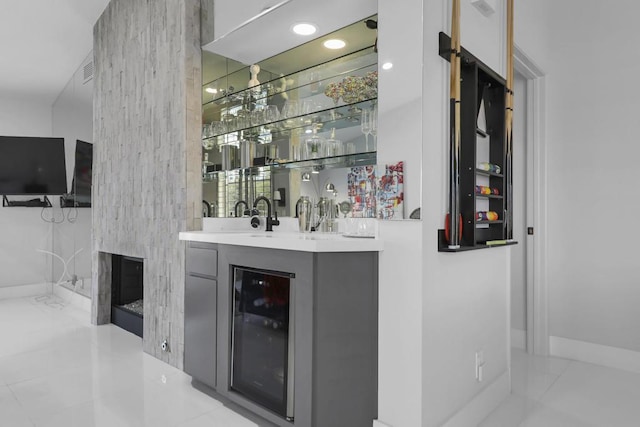 bar featuring wine cooler, light tile patterned floors, sink, and gray cabinetry