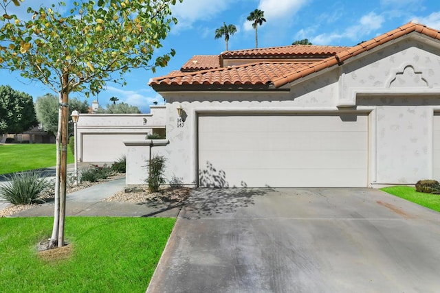 mediterranean / spanish home featuring a garage and a front lawn