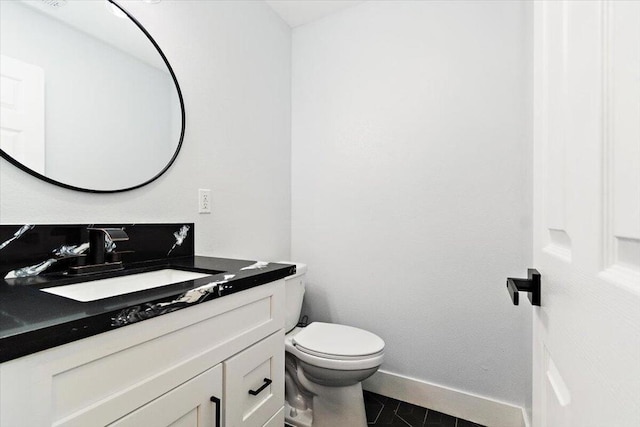 bathroom with toilet, vanity, and tile patterned flooring