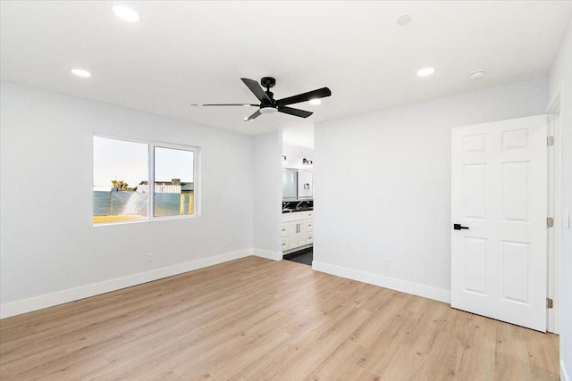 interior space featuring ceiling fan, light wood-type flooring, and ensuite bathroom