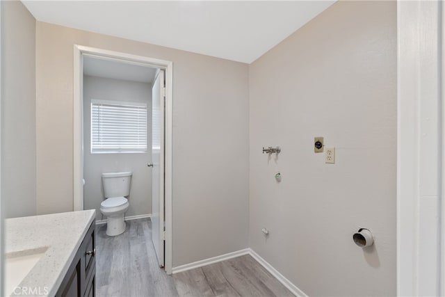 bathroom featuring wood-type flooring, toilet, and vanity