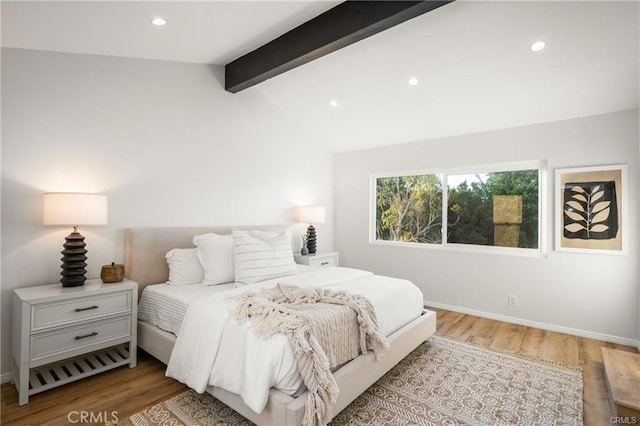 bedroom with light wood-type flooring and vaulted ceiling with beams