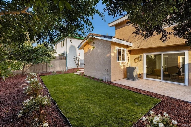 view of yard with central air condition unit and a patio