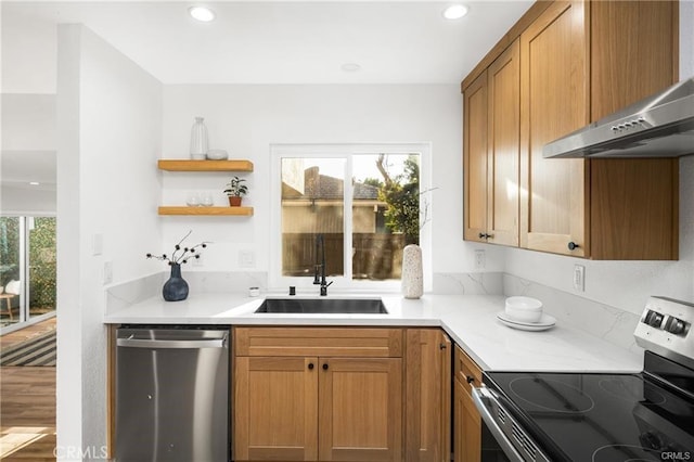 kitchen featuring appliances with stainless steel finishes, sink, and wall chimney exhaust hood