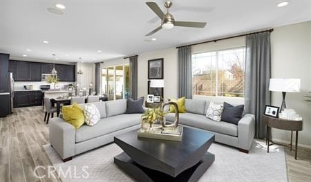 living room with ceiling fan and light hardwood / wood-style floors