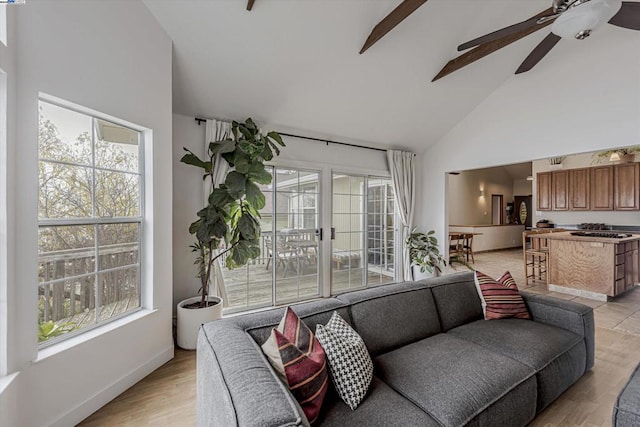 living room featuring ceiling fan, a wealth of natural light, light hardwood / wood-style floors, and high vaulted ceiling