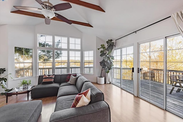 sunroom / solarium featuring a water view, lofted ceiling with beams, and plenty of natural light