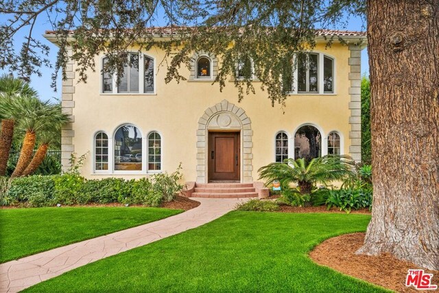 mediterranean / spanish-style house featuring a front yard