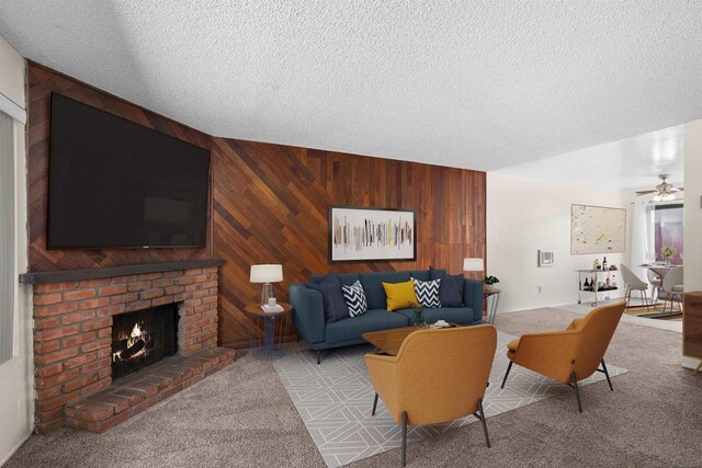 living room with light carpet, ceiling fan, a textured ceiling, and wood walls