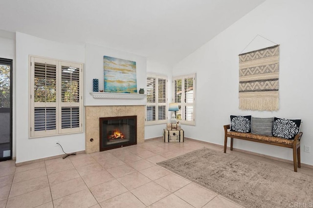 sitting room featuring a wealth of natural light, a tile fireplace, light tile patterned floors, and lofted ceiling