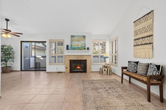 living room featuring ceiling fan, light tile patterned floors, lofted ceiling, and a fireplace