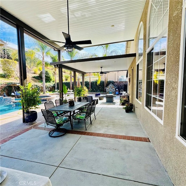 view of patio / terrace with ceiling fan and a swimming pool with hot tub