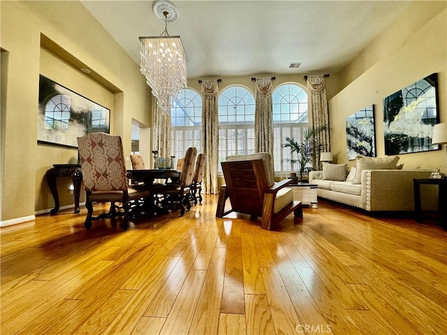 living area featuring light wood-type flooring and an inviting chandelier