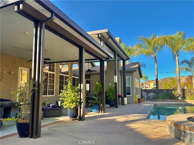 view of pool with a patio area and ceiling fan